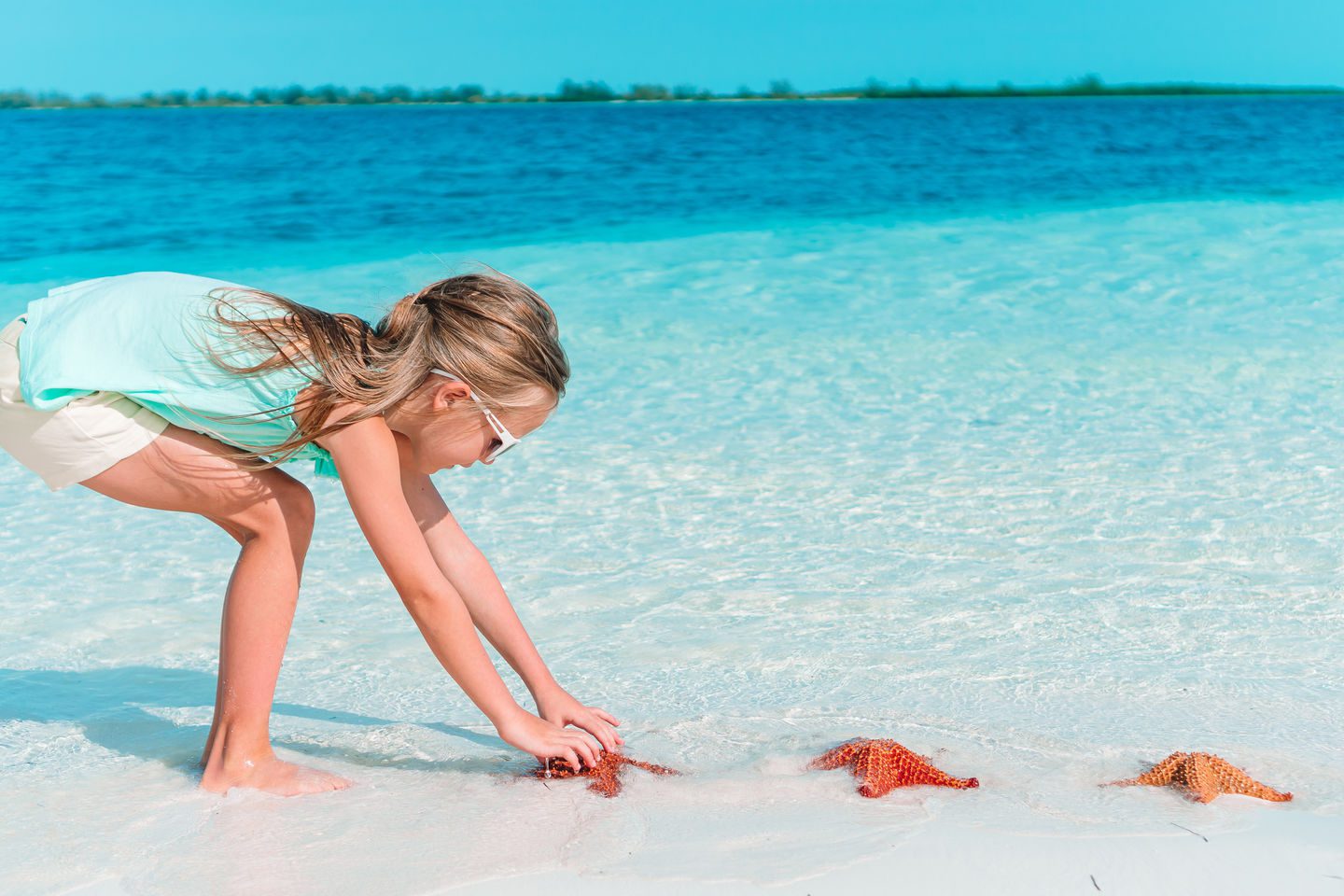 Adorable little girl at tropical beach on vacation