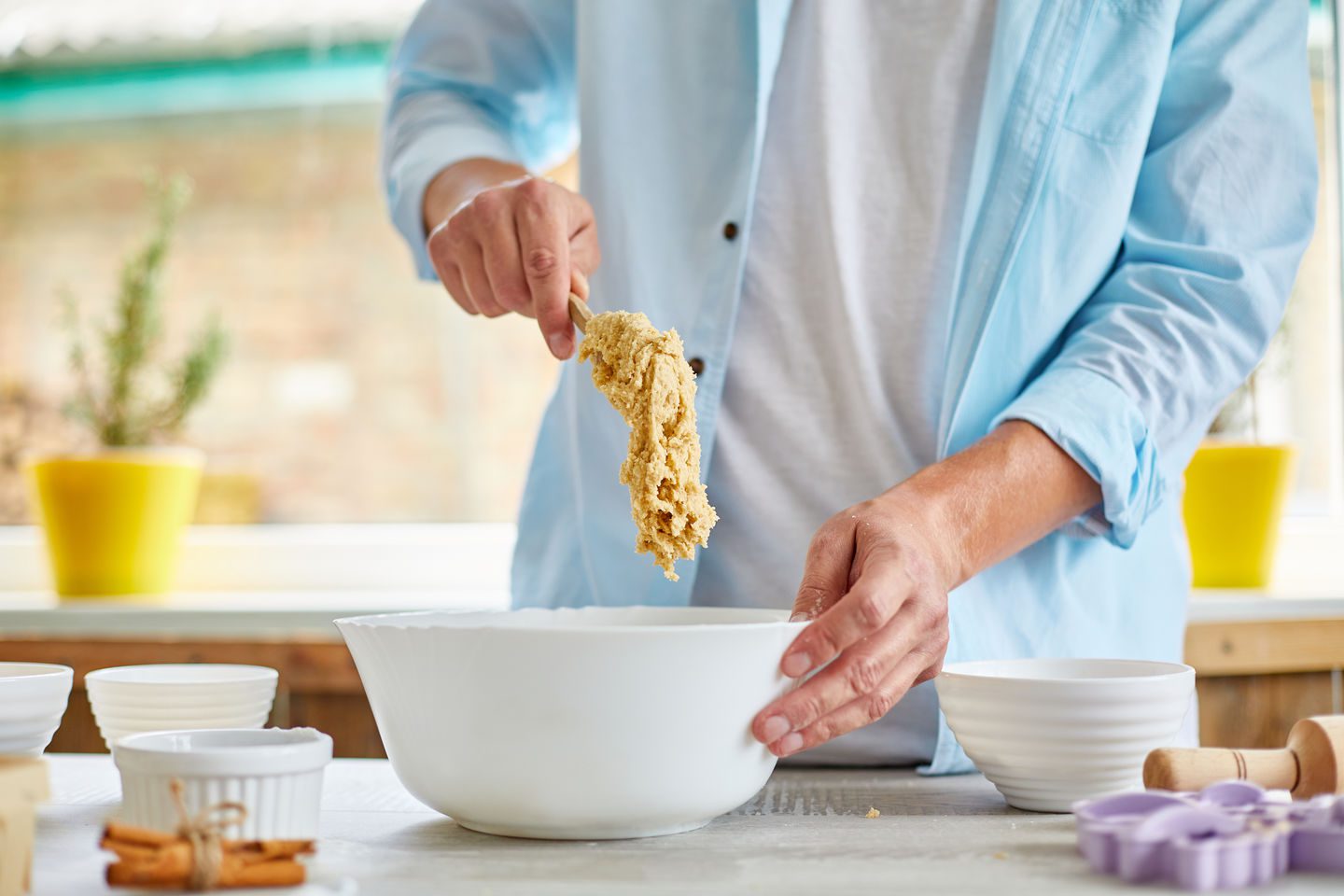 Man, male forming the dough in Bowl a and kneading at home in the kitchen, preparation for cookies, home cooking.