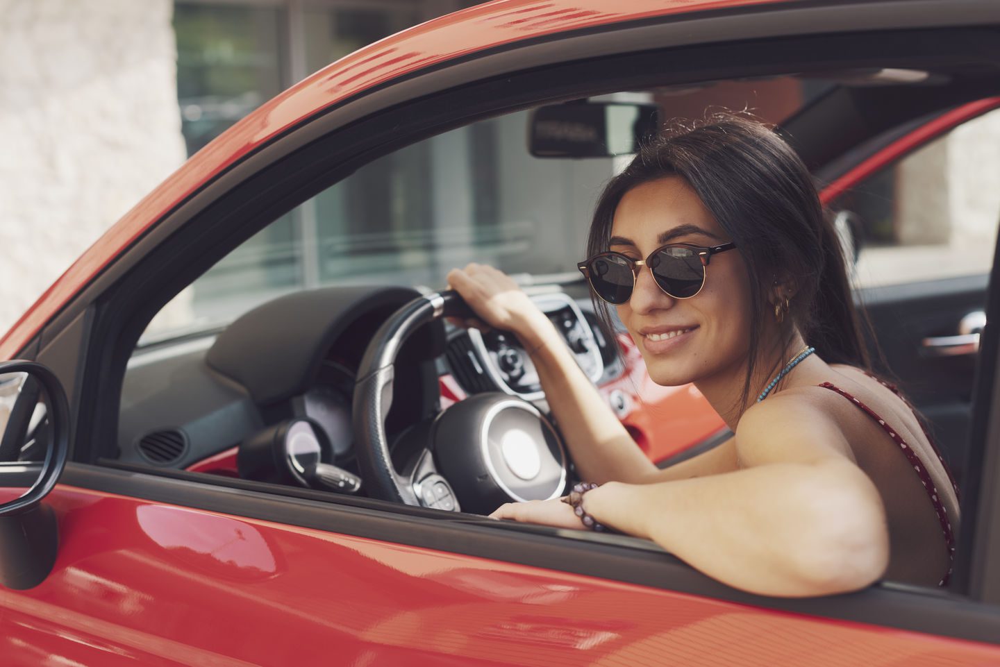 Portrait of beautiful happy young woman driver, sitting in a car